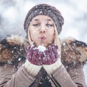 Portrait of a young blonde woman outdoors while snowing. Shallow DOF. Developed from RAW; retouched with special care and attention; Small amount of grain added for best final impression. Adobe RGB color profile.